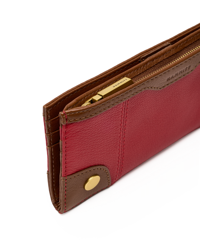 A close-up of a Barrie leather wallet in red and brown with gold-tone hardware, showing the interior card slots and zipper.