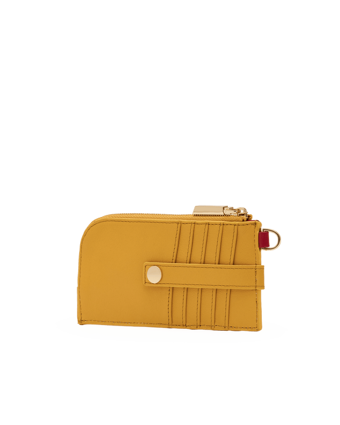 A mustard yellow leather zip-around wallet with a snap-button strap and gold-tone hardware, shown on a plain white background.