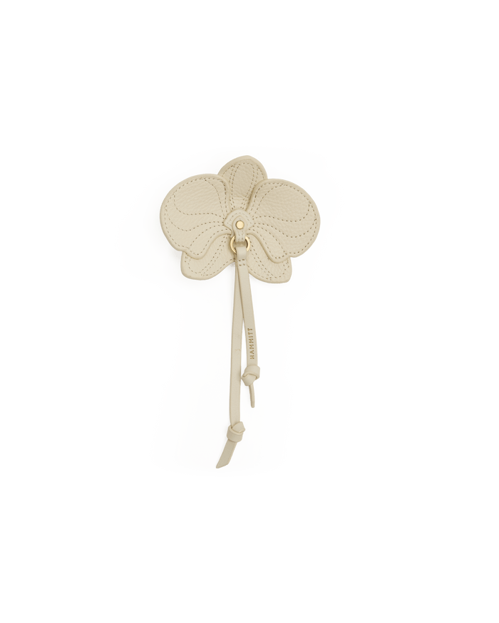 Decorative brooch on a white bust against a black background