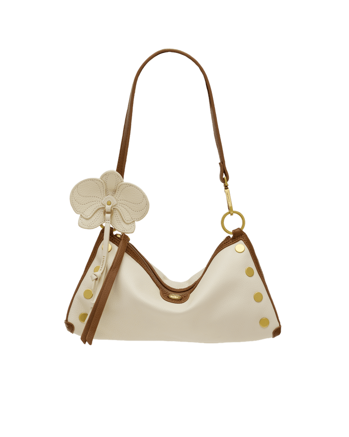 White handbag with brown accents and floral details on a black background