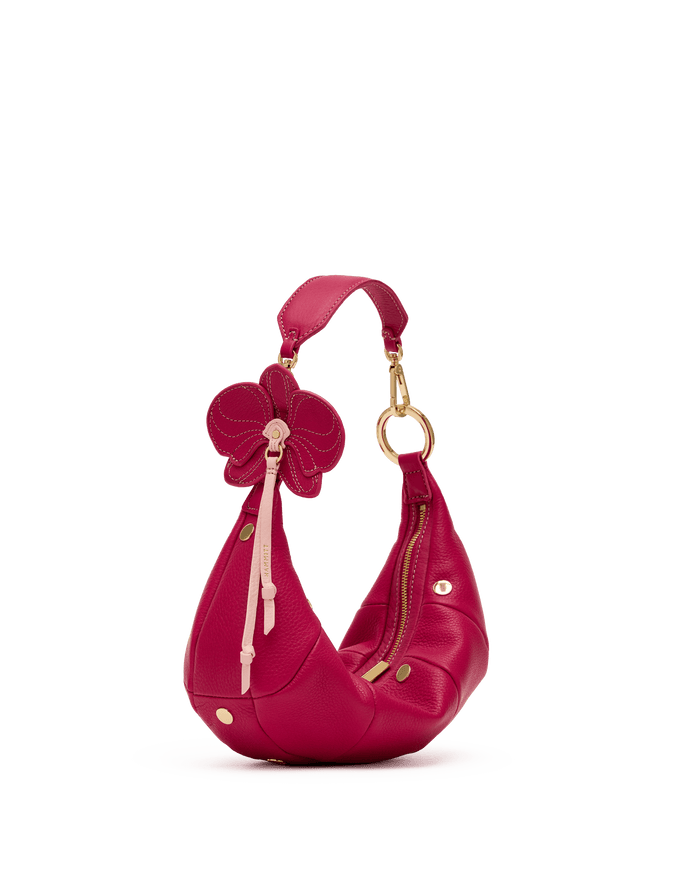 Pink handbag with floral design on a black background