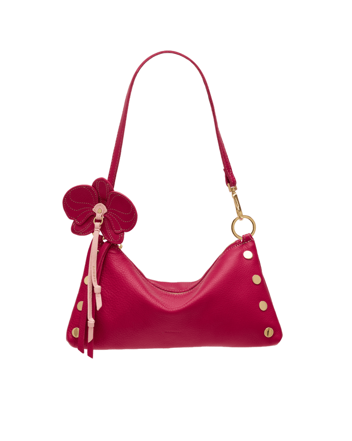 Pink handbag with floral design and gold accents on a black background