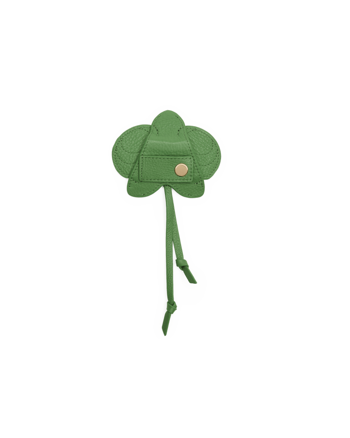 Green clover-shaped patch with a button on a black background