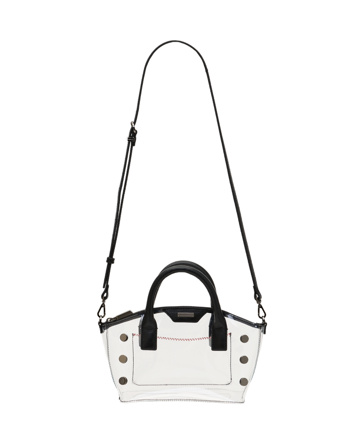 A clear vinyl handbag with black leather handles, a black shoulder strap, and silver-tone studs.