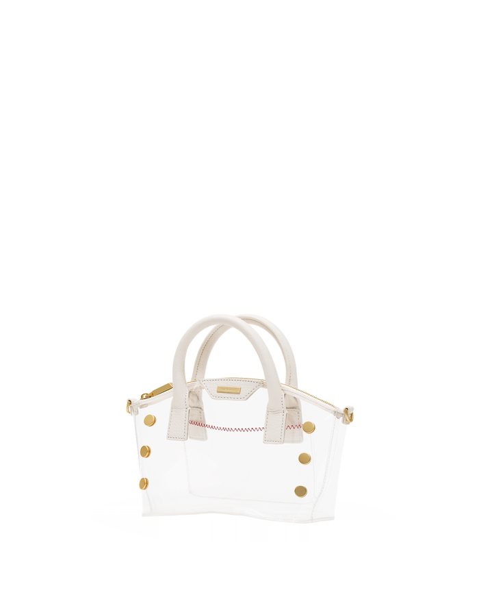 A small structured handbag with a transparent white body, cream-colored top handles, and gold-tone hardware, including decorative studs and a zipper pull.