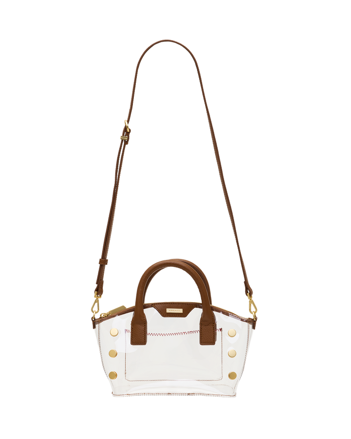 A clear acrylic handbag with brown leather handles, trim, and a shoulder strap, accented by gold-tone studs and hardware.