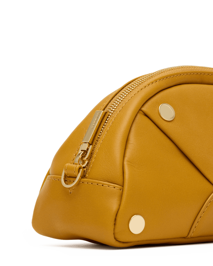Yellow leather bag with gold accents on a white background
