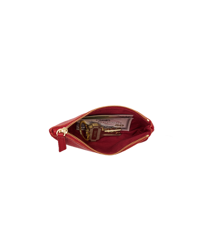 A small red leather zippered pouch shown open, revealing a gold zipper, interior lining, and contents including a key and a card, isolated on a white background.