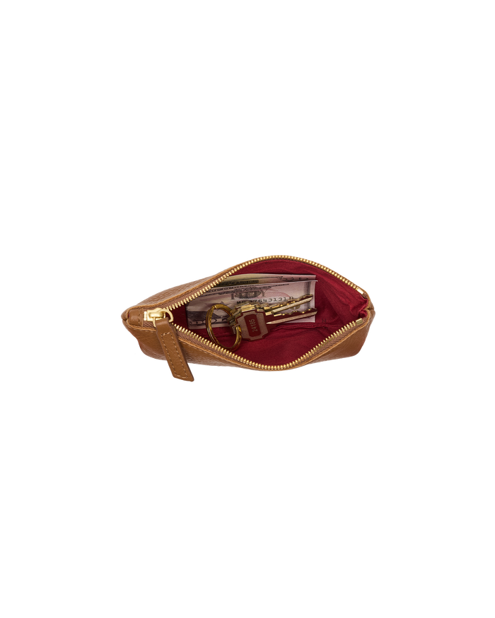 A tan leather zippered pouch shown open, revealing a deep burgundy red interior lining and gold-tone hardware, with a small keychain and cardholder inside.