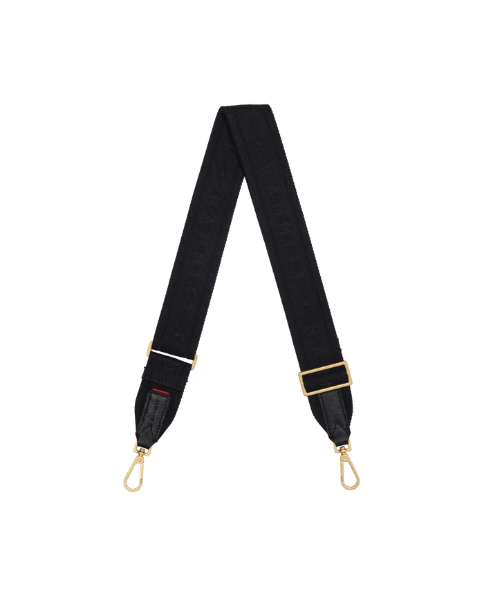A black fabric camera strap with gold-tone hardware, featuring a repeating monogram pattern and adjustable buckle.