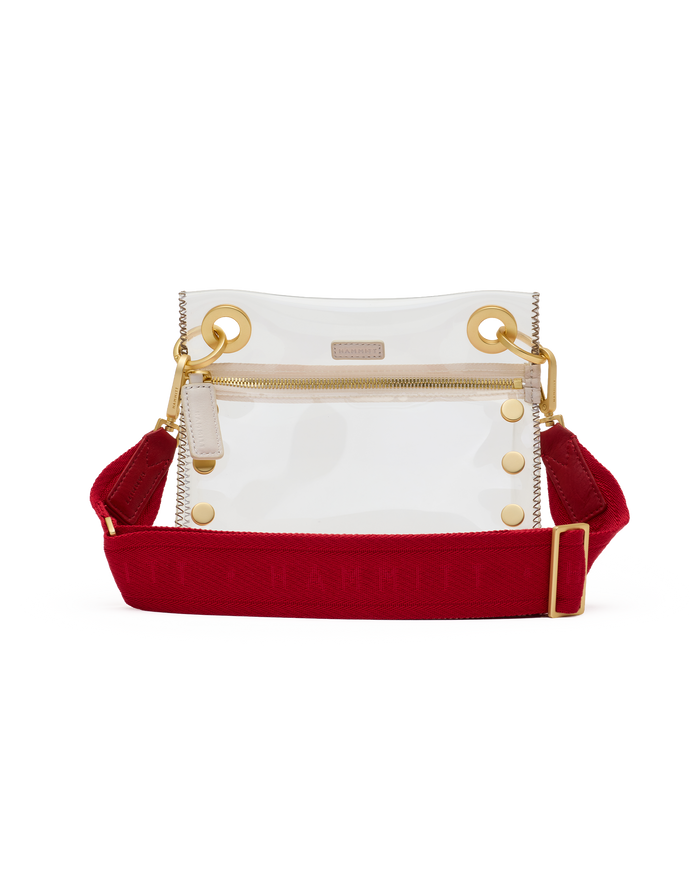 Clear handbag with red accents and gold hardware on a white background